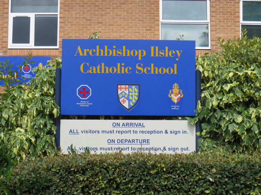 Archbishop Ilsley Catholic school and sixth form school's sign outside the school building. With name logo and information.