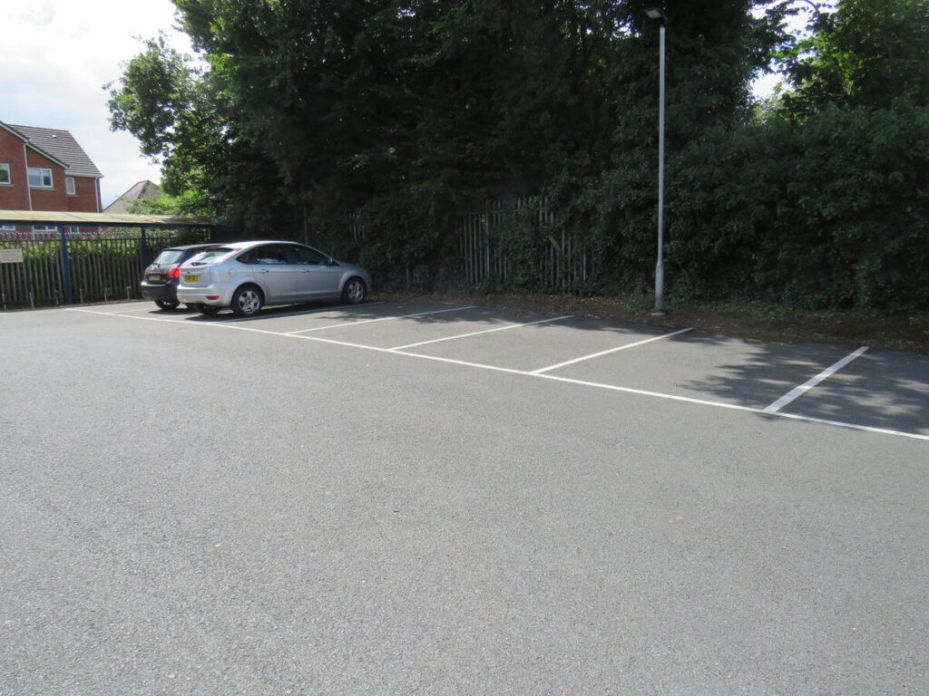 School car park parking with two cars parked in car parking spaces.