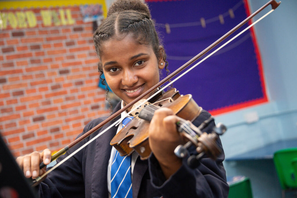 Pupil in music class/lesson playing the Violin.