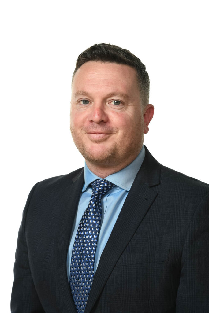 Portrait headshot photo of James Simmons, assistant headteacher. White background.